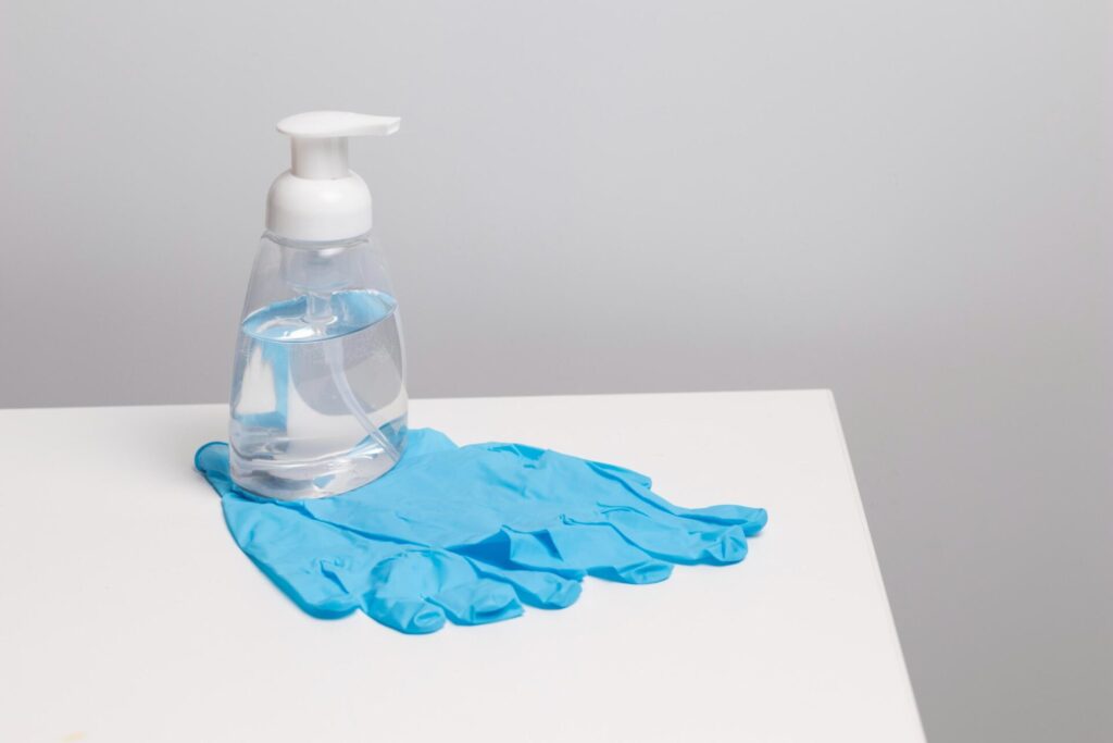 یک بطری ایزوپروپیل الکل، نحوه تمیز کردن ناخن‌گیرها با مواد ضدعفونی‌کننده را نشان می‌دهد.